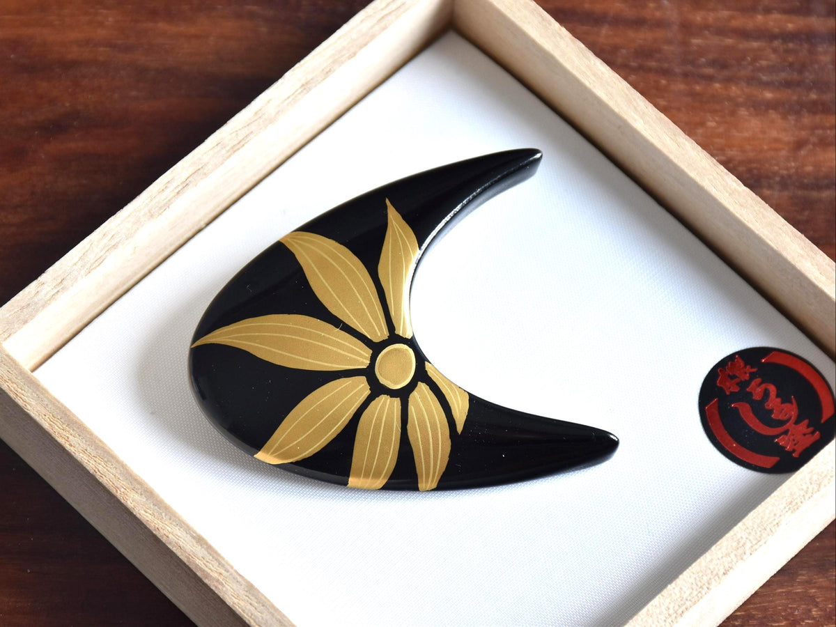 Urushi lacquer floral brooch displayed inside its original wooden presentation box with a red and black sticker
