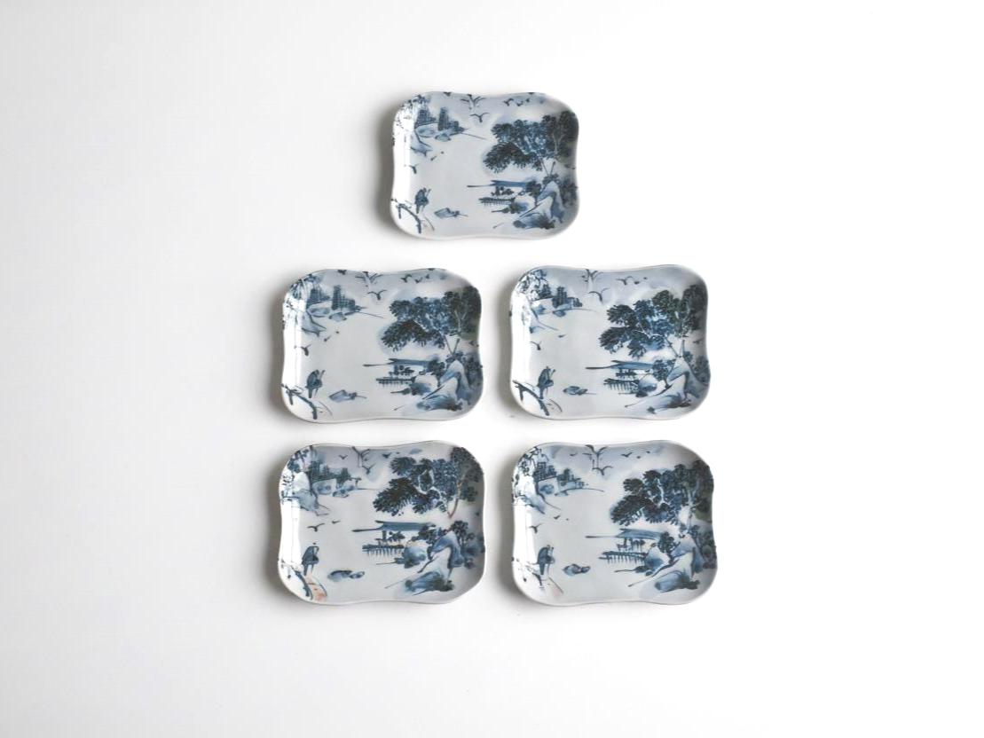 Tōsai Kiyomizu-yaki porcelain plates laid out in a group against a plain background