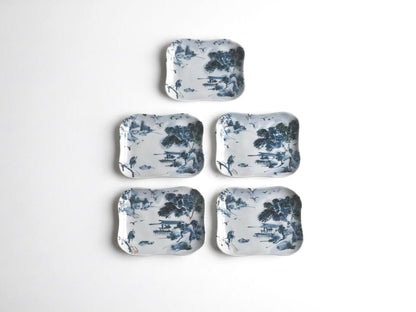 Tōsai Kiyomizu-yaki porcelain plates laid out in a group against a plain background