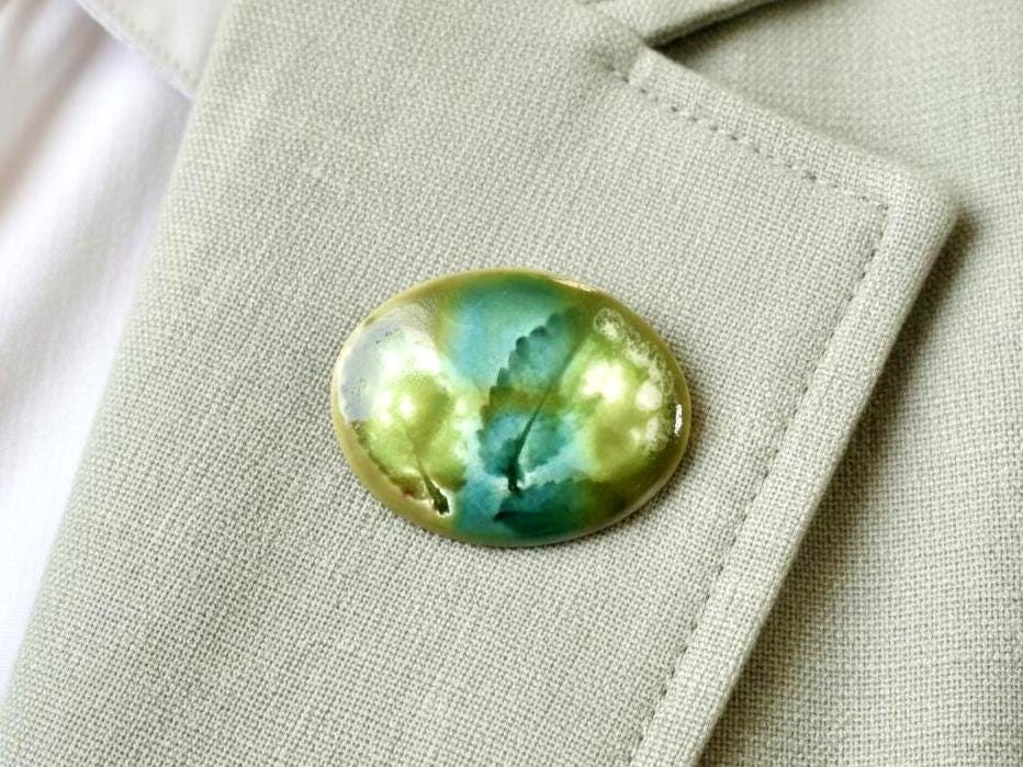 Kutani Ceramic Brooch Leaf Motif vintage Japanese craft accessory pinned on a grey fabric jacket