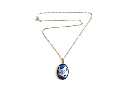 Japanese Cobalt Blue Floral Porcelain Pendant Necklace laid flat on a white surface