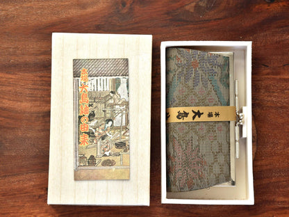 Oshima Tsumugi Silk Gamaguchi Coin Purse Brown shown inside presentation box
