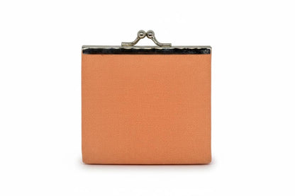 Peach Gamaguchi coin purse back view showing plain fabric surface