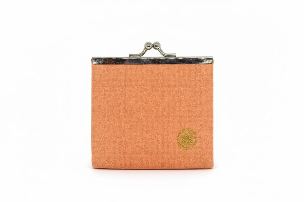 Peach Gamaguchi coin purse front view showing gold chrysanthemum motif