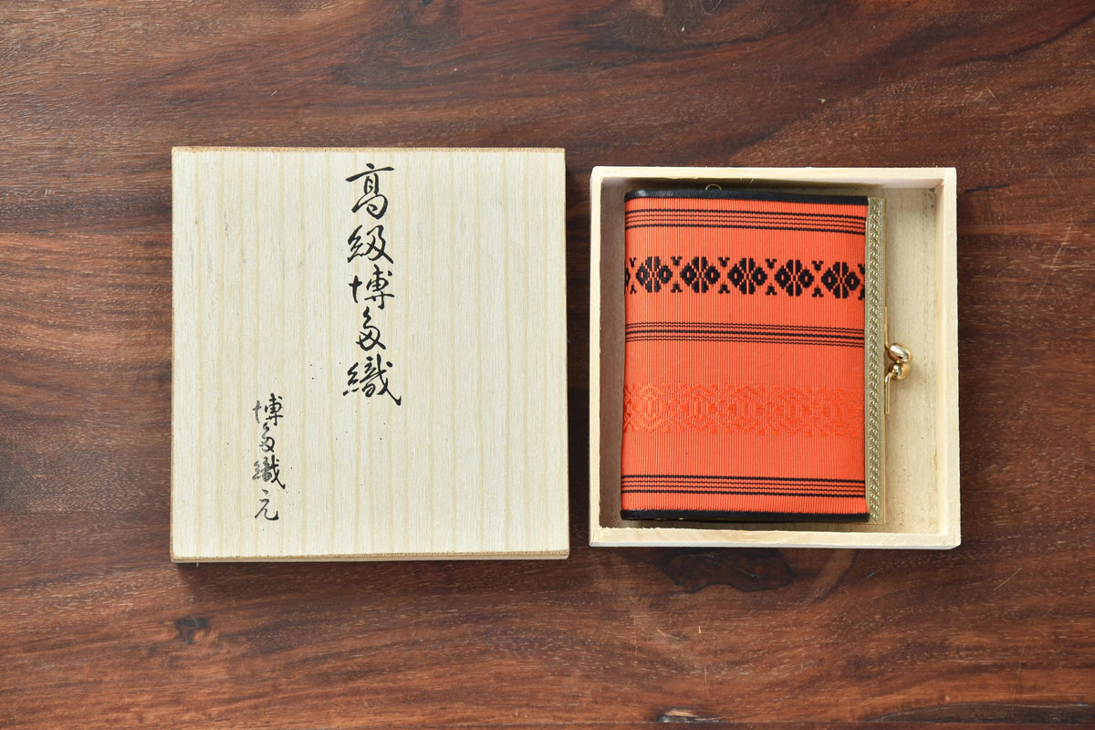 Vermilion Hakata-Ori Silk Clasp Coin Purse nestled neatly inside its open wooden storage box