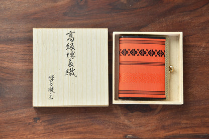 Vermilion Hakata-Ori Silk Clasp Coin Purse nestled neatly inside its open wooden storage box