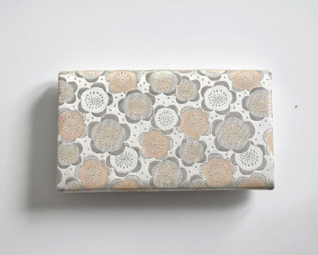 Nishijin-Ori silk clutch back view showing the continuous plum blossom brocade pattern