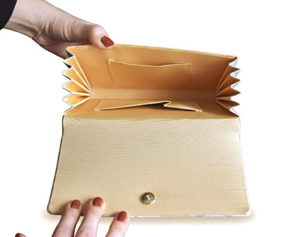 Nishijin-Ori silk clutch opened to show the accordion sides and yellow fabric lining inside