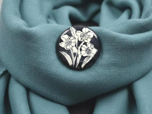Kiyomizu Porcelain Brooch Narcissus Motif Kyoto ceramic jewelry on teal fabric
