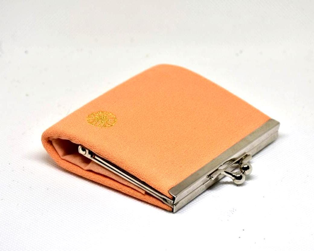 Peach Gamaguchi coin purse angled side view showing depth and clasp