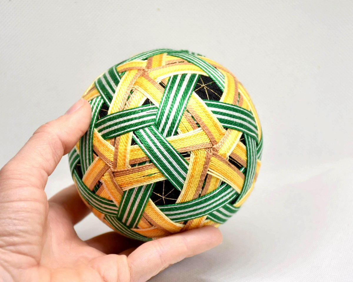 Temari Ball Embroidery held in a hand to demonstrate its 10 cm size