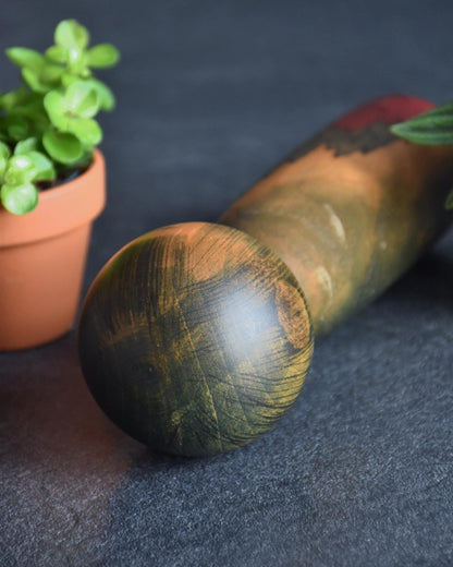 Usaburo kokeshi doll lying down showing top of head and grain