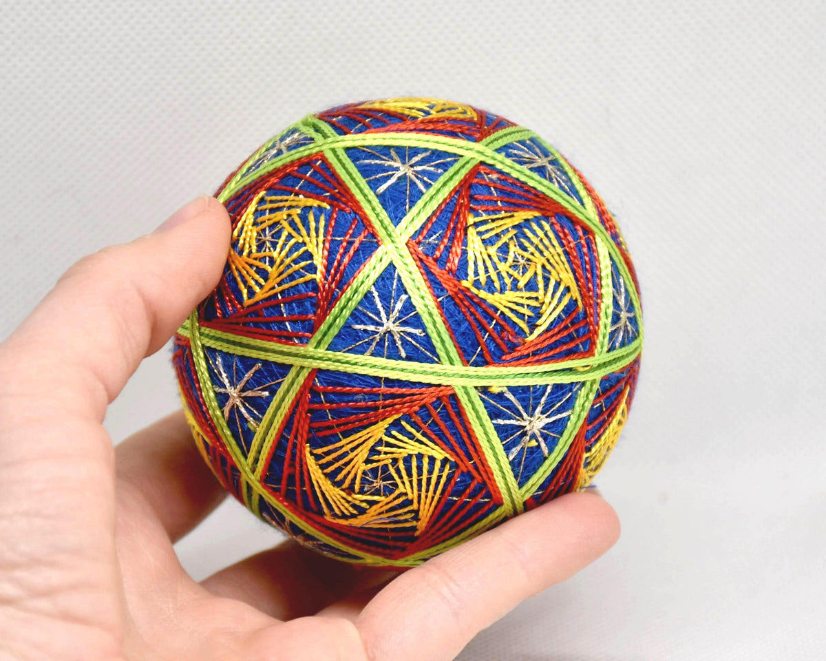 Hand-Embroidered Japanese Temari Ball shown next to a hand for scale