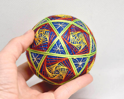 Hand-Embroidered Japanese Temari Ball shown next to a hand for scale