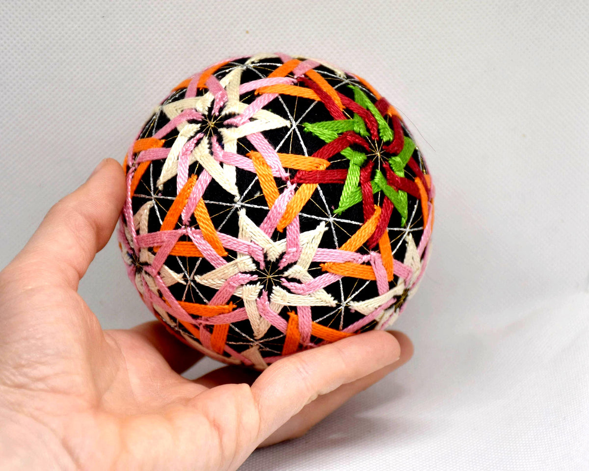 Temari ball hand embroidery shown next to a hand to indicate the 10 cm size