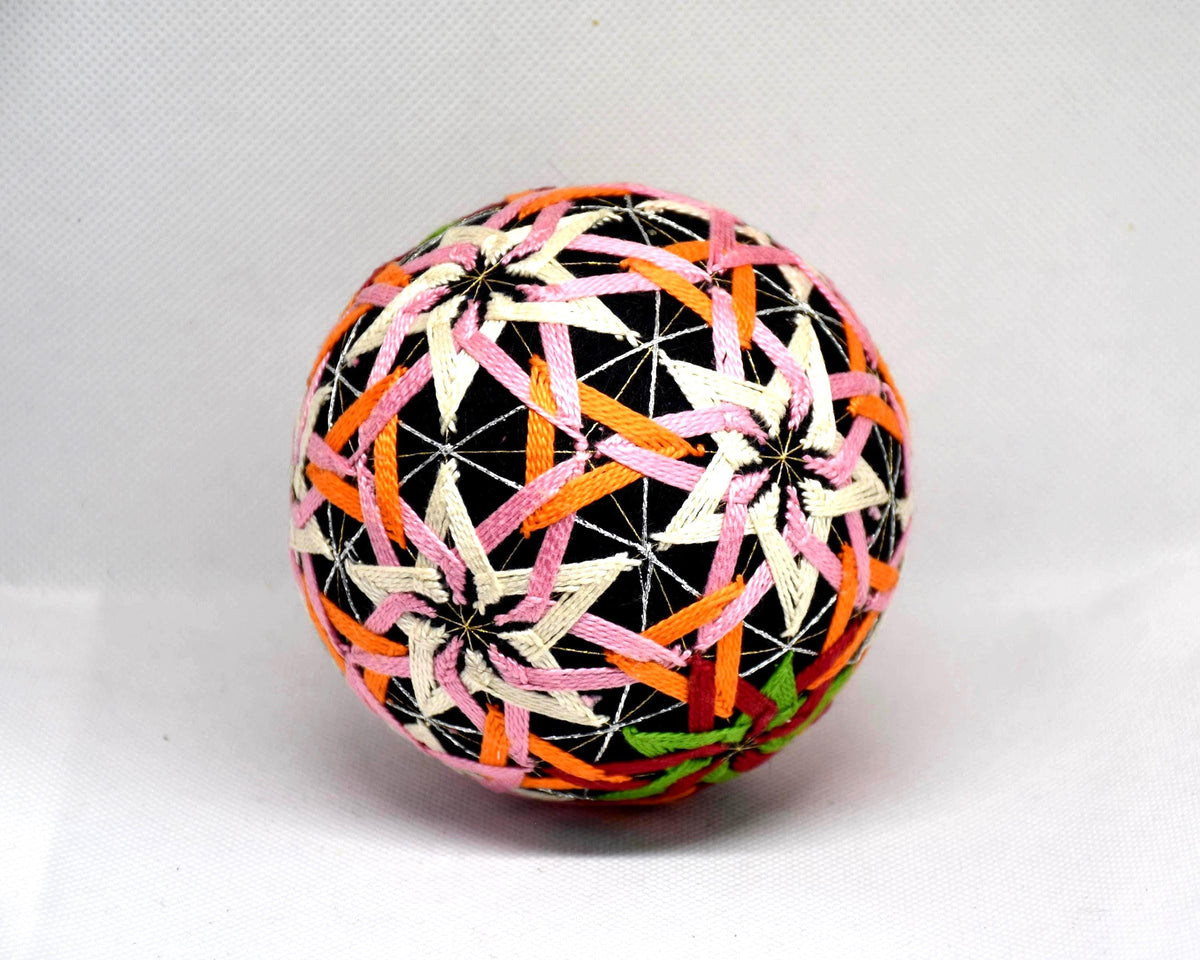 Temari ball hand embroidery viewed from another angle displaying the woven thread patterns
