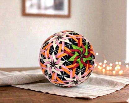 Temari Ball Hand Embroidery traditional Japanese folk art folk object on a wooden table with string lights