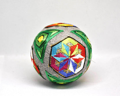 Hand-Embroidered Japanese Temari Ball Folk Art shown next to a hand for scale