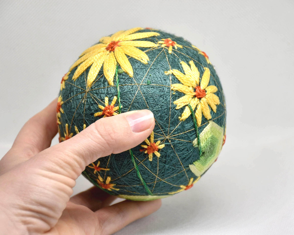 Temari Ball Hand Embroidery traditional Japanese craft shown next to a hand to demonstrate its size