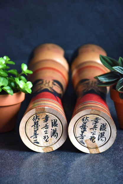 Zenji Sato kokeshi dolls showing the base with handwritten artist signatures