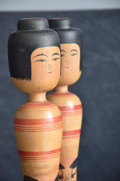 Zenji Sato Tsugaru kokeshi pair close-up of the serene wooden faces and hair