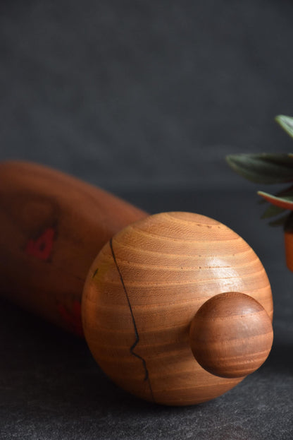 Toa Sekiguchi kokeshi head close-up highlighting the round wooden finial and grain