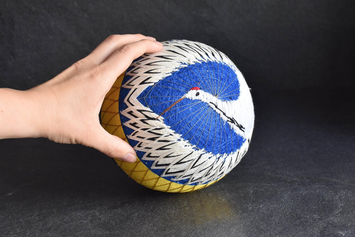 Geometric Black And White Embroidered Temari Ball held in hand for size context