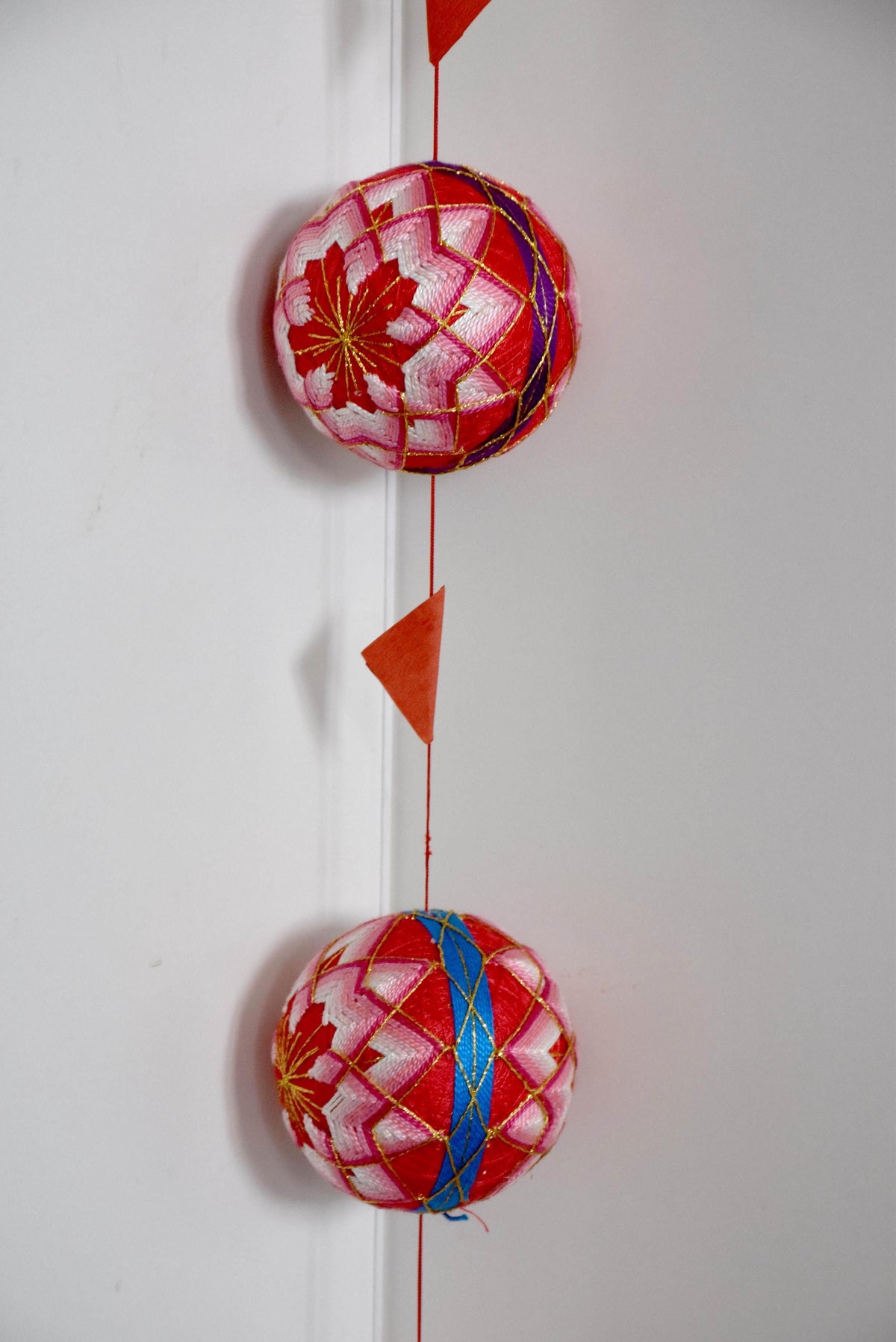 Set Of 5 Hand-Embroidered Japanese Temari Balls hanging vertically as a decorative display string.