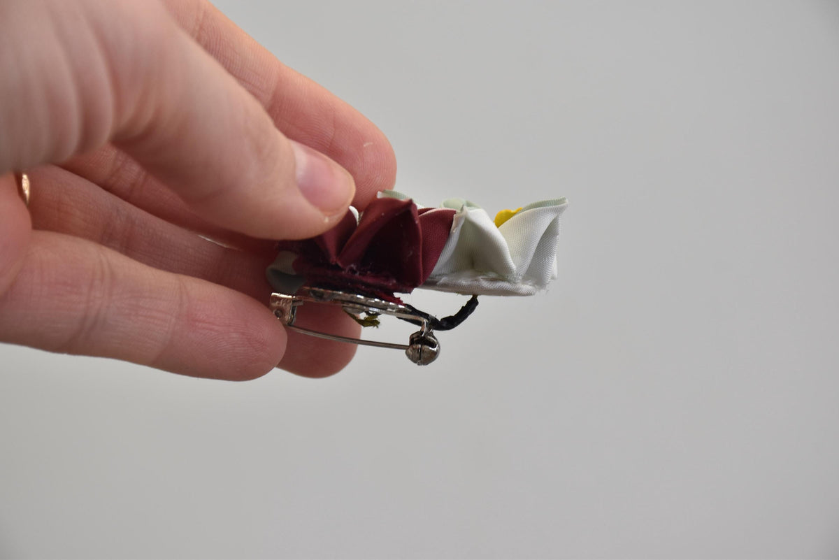 Tsumami Zaiku floral fabric brooch side view held in fingers