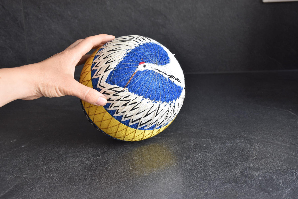 Geometric Black And White Embroidered Temari Ball shown next to hand from another angle