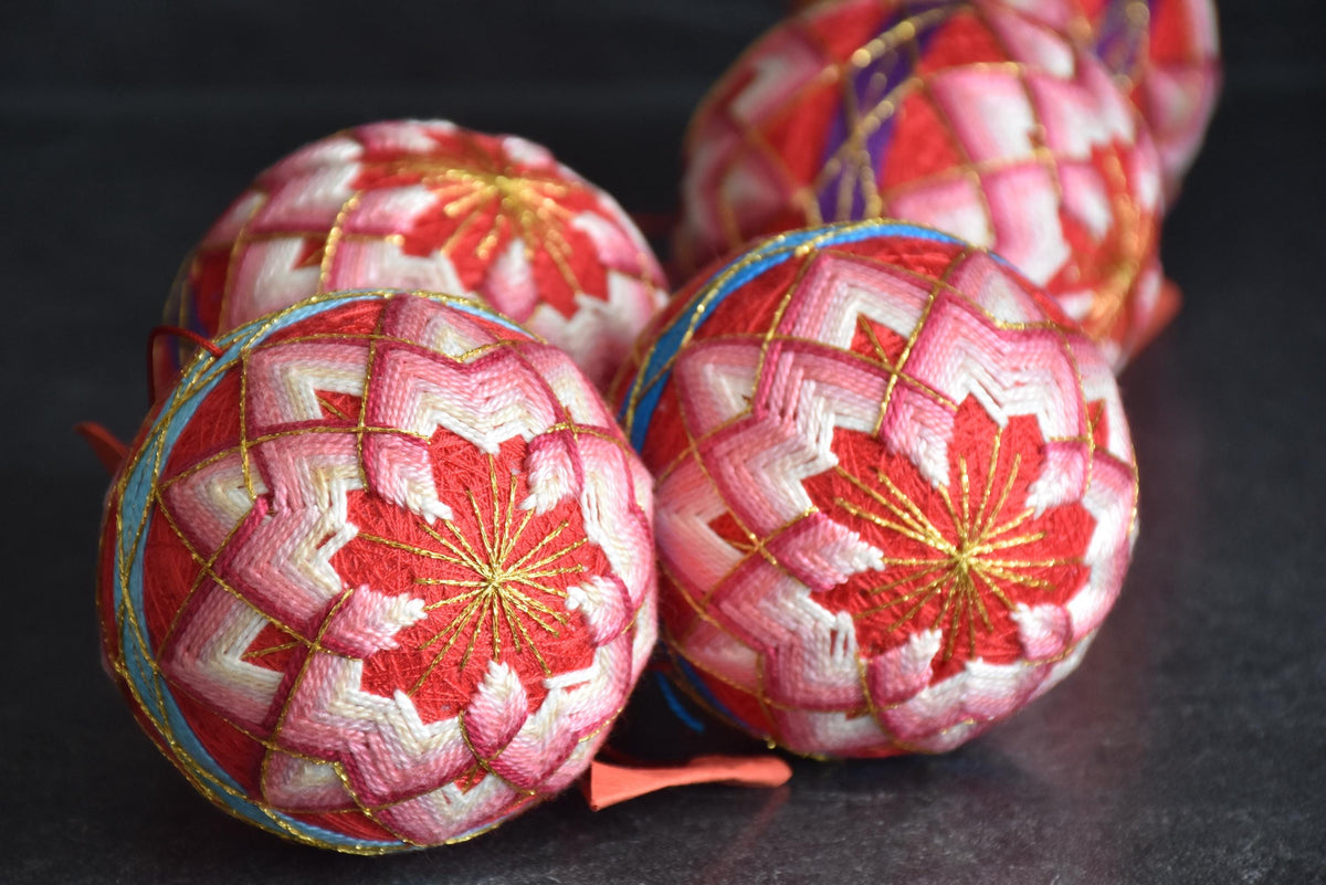 Set Of 5 Hand-Embroidered Japanese Temari Balls grouped closely together to display design variations.