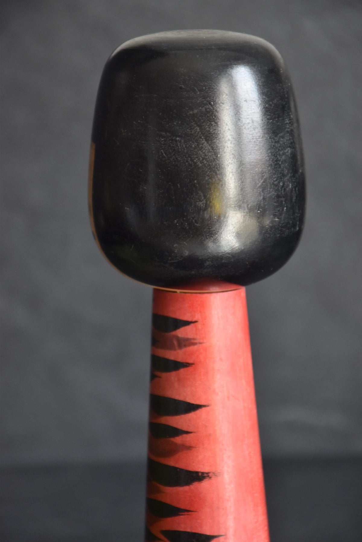 Hideo Ishihara kokeshi doll, pattern detail showing rhythmic black brushstrokes on red base