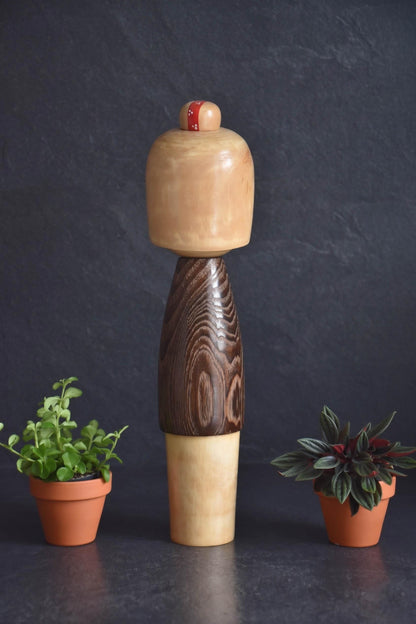 Usaburo kokeshi doll shown from the back view displaying the dark wood grain pattern