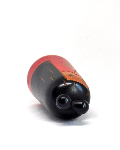Japanese Kokeshi Doll With Black Ribbon showing the top view of the black ribbon detail