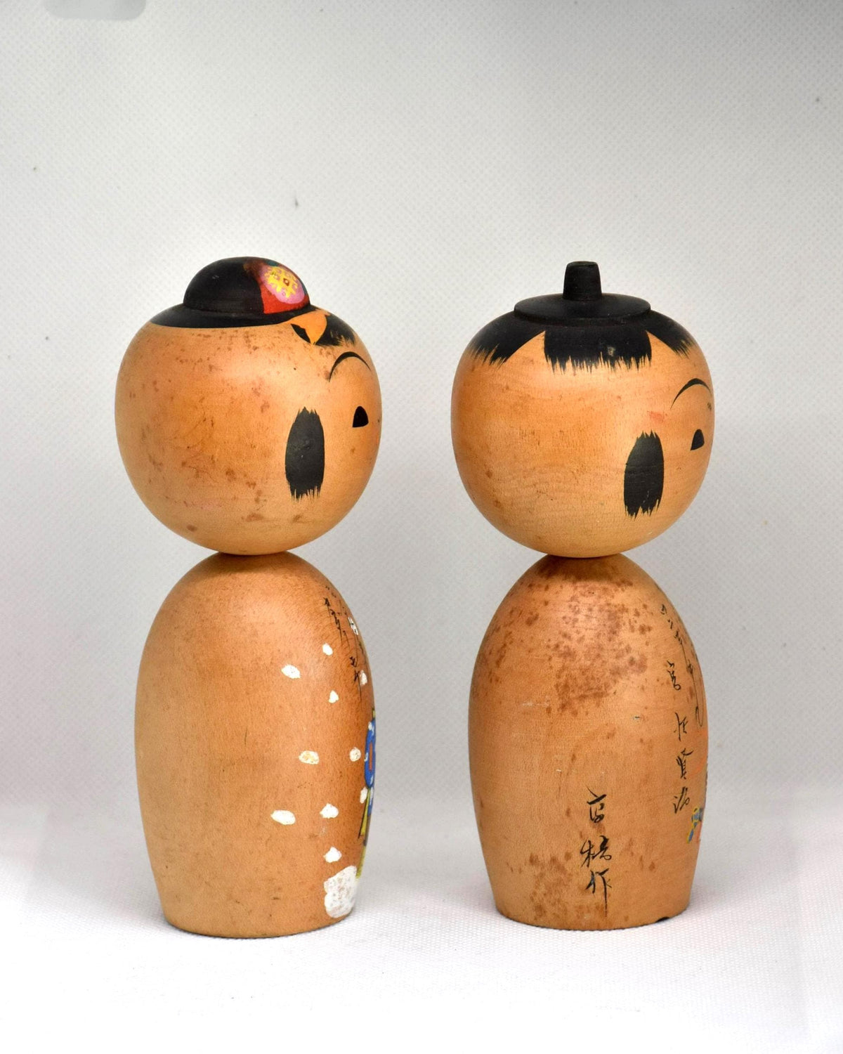 Hand-Painted Calligraphy Kokeshi Doll Pair side view showcasing hand-painted figures and script writing.
