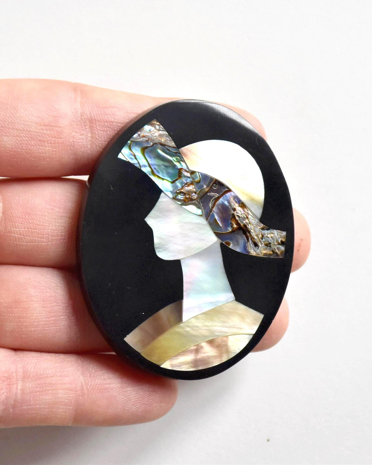 Raden shell inlay brooch woman portrait, front view of the Japanese handmade mother-of-pearl pin in hand