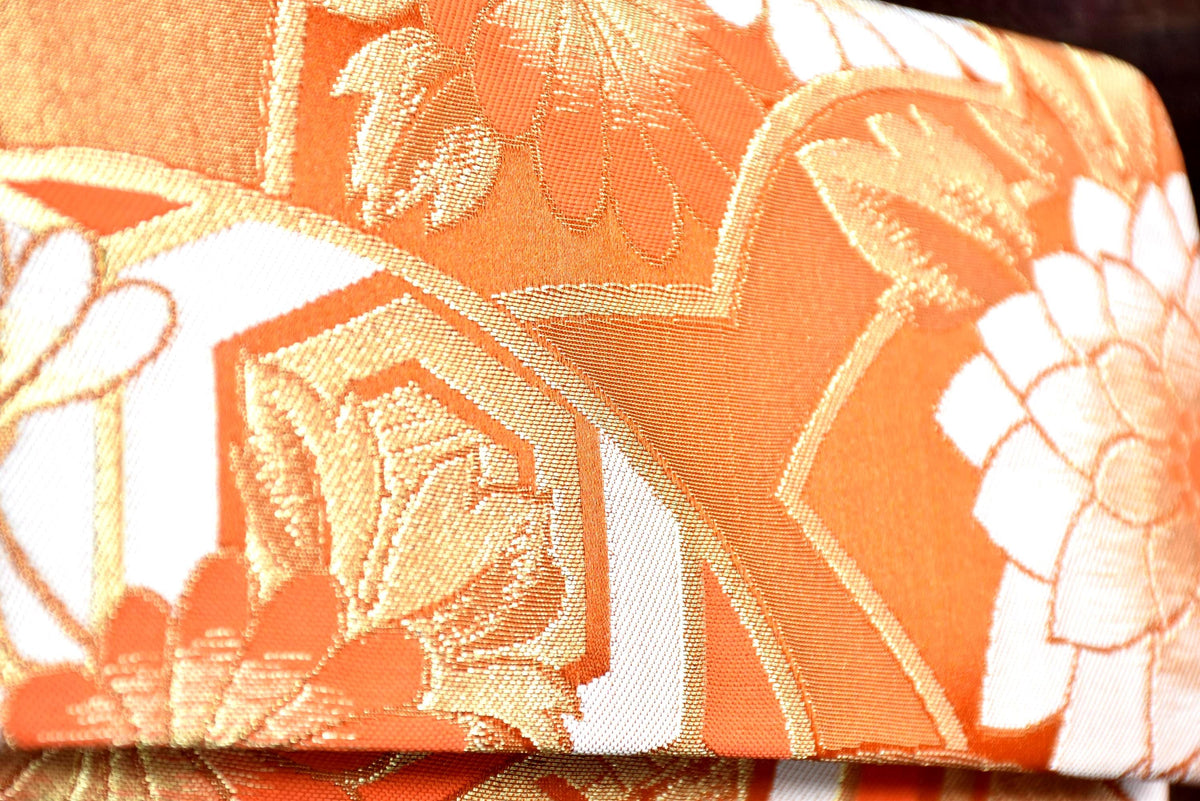 Saga Nishiki brocade clutch handbag detailed view of the shimmering gold and white floral brocade pattern.