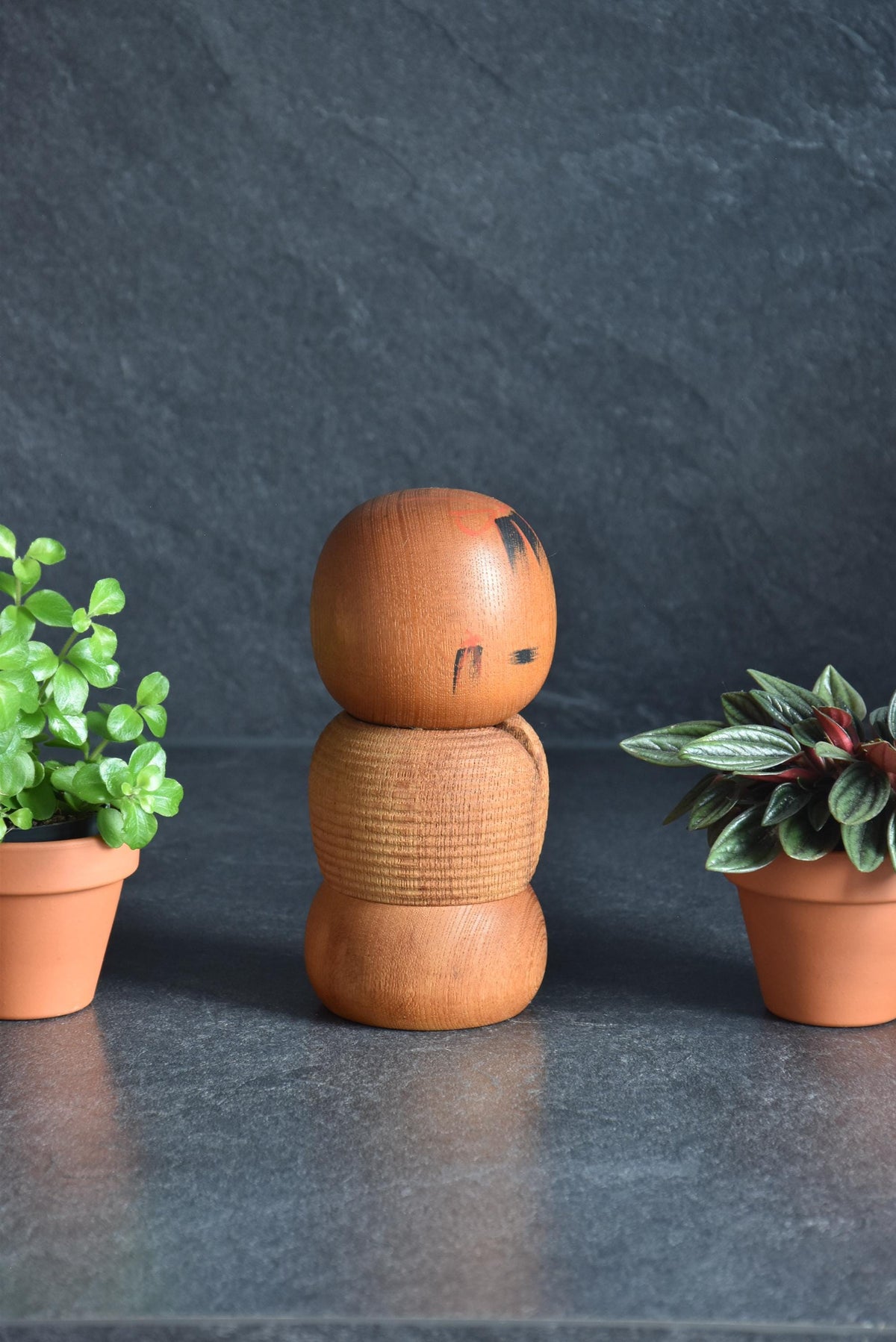 Aida Seihou kokeshi doll turned slightly to display side facial details and wood texture