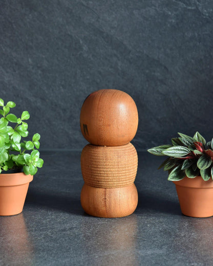 Aida Seihou kokeshi doll showing the plain back of the wooden head and textured body