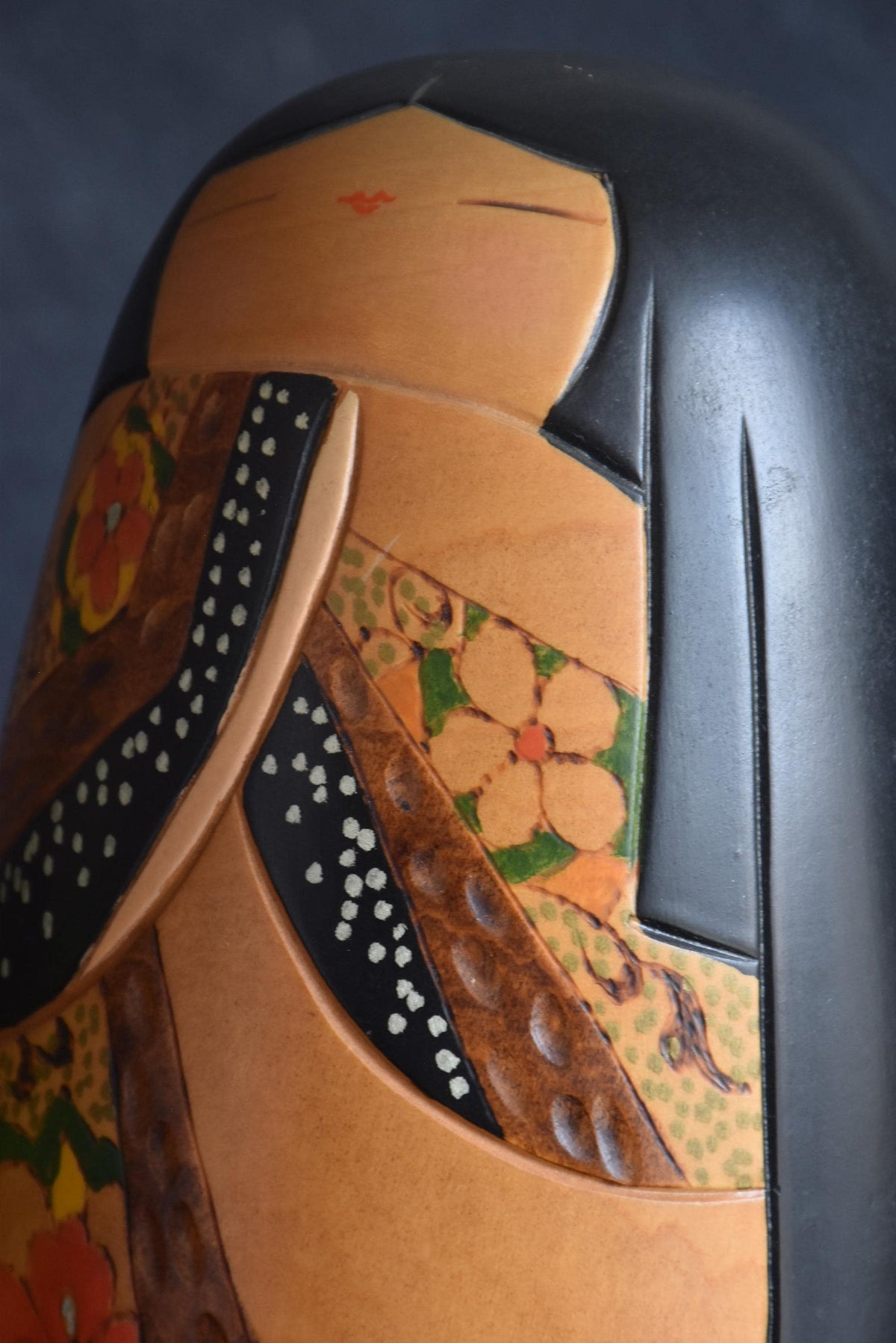 Close-up of painted floral motifs and chiseled wood textures on kimono