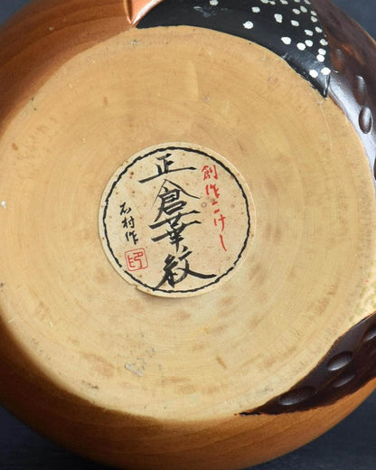 Close-up of paper label and artisan stamp on the base of Ishimura Sosaku kokeshi