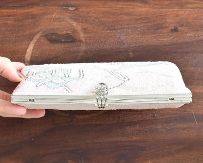 Japanese beaded clutch top metal frame and decorative clasp held by hand