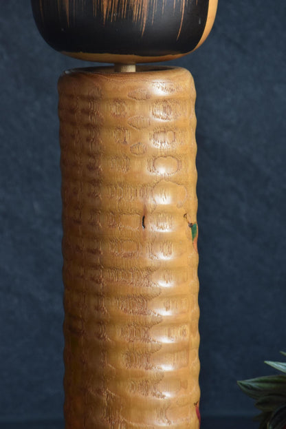 Usaburo Sosaku Kokeshi doll, pattern detail of the scalloped textured body and autumn maple leaves
