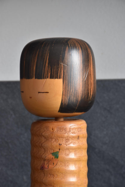 Usaburo Sosaku Kokeshi doll close-up of face with meditative expression and small facial scratch