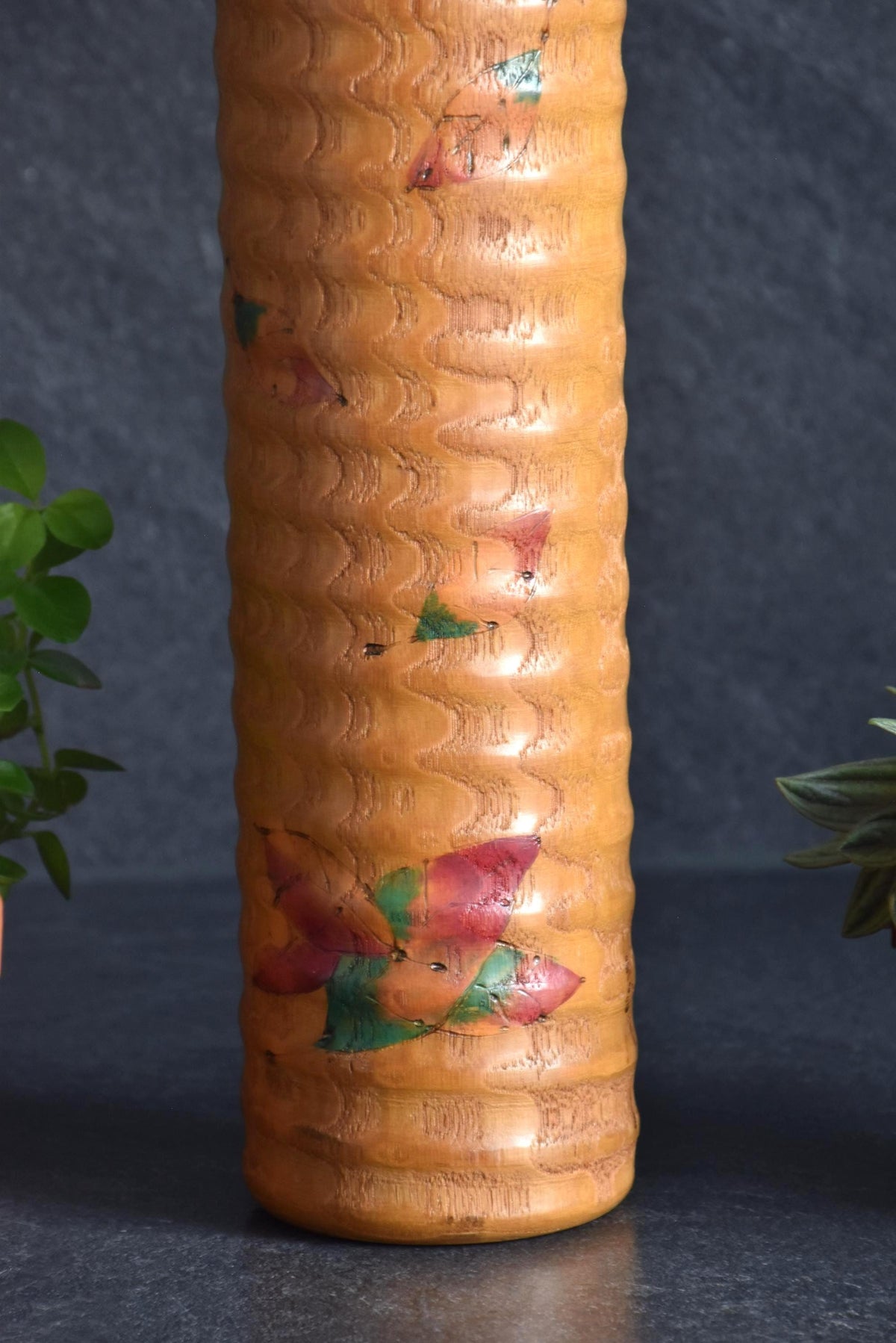 Usaburo Sosaku Kokeshi doll close-up of the hand-painted falling autumn maple leaves pattern