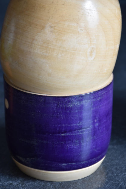 Sato Suigai kokeshi showing a detailed view of the wrapped purple kimono body