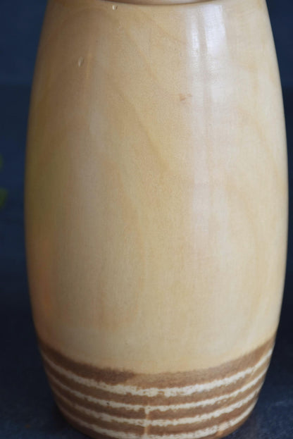 Chiyomatsu Kano kokeshi doll body showing cylindrical wooden form with textured base pattern