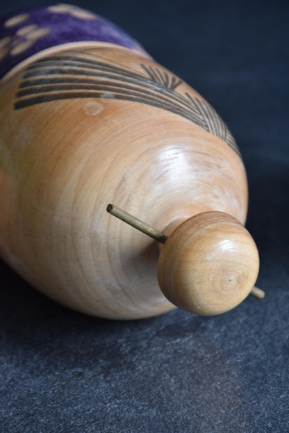 Sato Suigai kokeshi showing a close-up of the topknot and wooden kanzashi hairpin