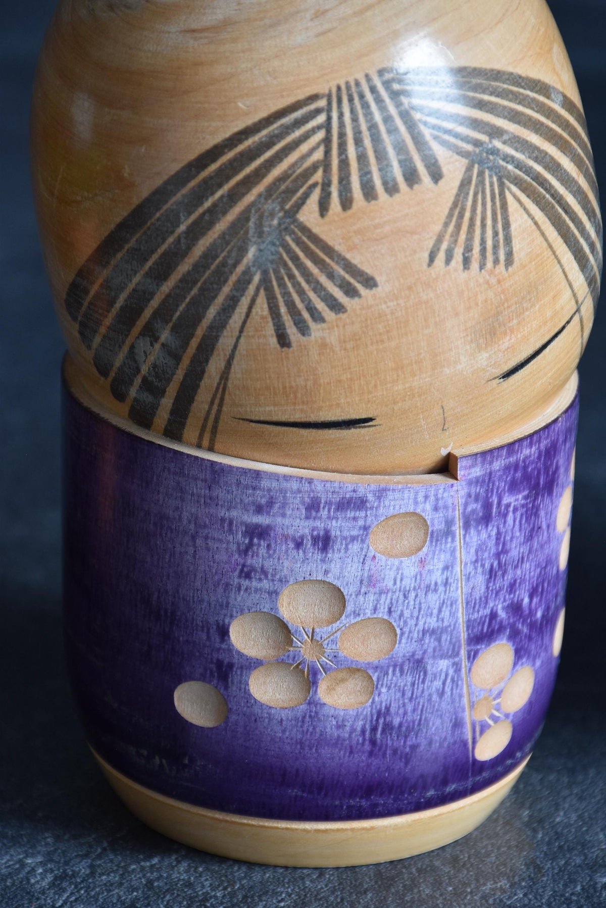 Sato Suigai kokeshi showing a close-up of the carved plum blossom kimono pattern