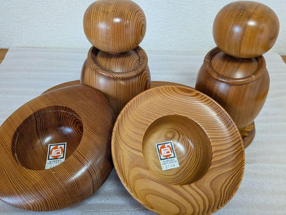 Yakusugi Cedar Sosaku Kokeshi Dolls with hats removed to reveal the rounded heads and authenticity stickers
